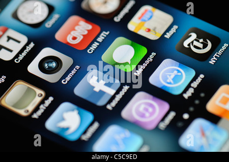 Eine Nahaufnahme von einem beleuchteten Apple iPhone 4 Bildschirm zeigt den App Store und verschiedenen apps Stockfoto