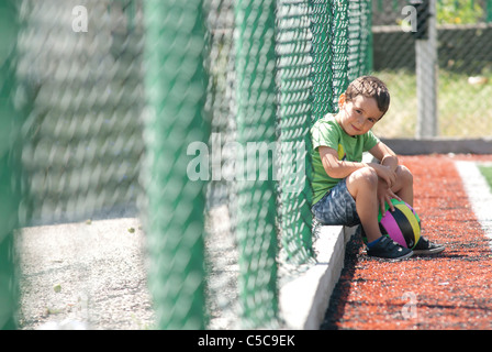 ein Junge mit Rest nach Fußballspiel Stockfoto