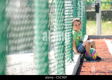 ein Junge mit Rest nach Fußballspiel Stockfoto