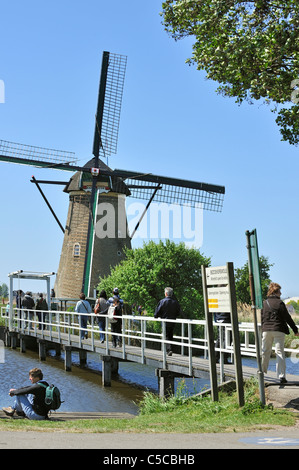 Touristen, die steinernen Entwässerung Windmühle am Kinderdijk, ein UNESCO-Weltkulturerbe in Süd-Holland, Niederlande Stockfoto