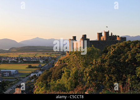 Sonnenuntergang in Harlech Castle mit der dreieckigen Spitze des Mount Snowdon in der Ferne, Gwynedd, Wales UK Stockfoto