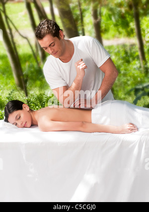 Einen männlichen Masseur massieren mit einer Frau im freien Stockfoto