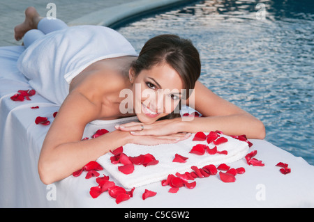 Lächelnde junge Frau im Spa mit Pool im Hintergrund Stockfoto