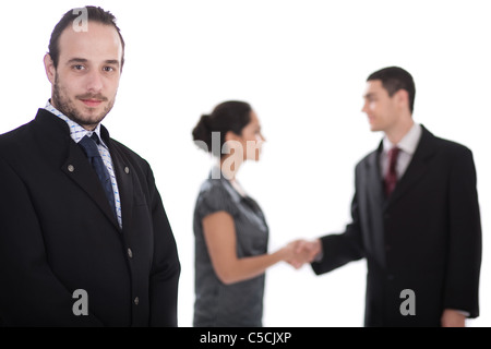 Gut aussehend Geschäftsmann schaut uns, zwei Kolleginnen und Kollegen so Handshake unscharf in isolierten weißen Hintergrund Stockfoto