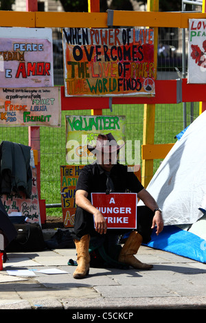 Protestler mit Plakat „Hungerstreik“ und Zigarre beim Parliament Square Peace Campaign / Brian Haw Peace Camp, Westminster, London, Großbritannien Stockfoto