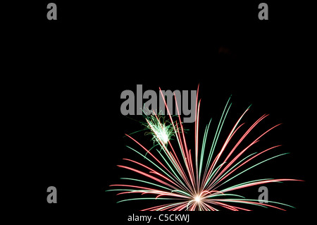 Rote und grüne Feuerwerk explodiert in den Nachthimmel. Ein Fest der Farben und Explosionen! Stockfoto