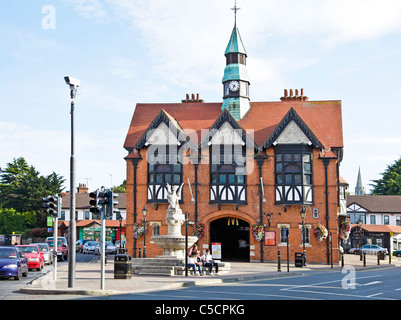 Drei Jugendliche sitzen unter einer Statue von einem Wyvern vor dem alten Rathaus, jetzt ein McDonalds. Bray, Co. Wicklow Irland Stockfoto