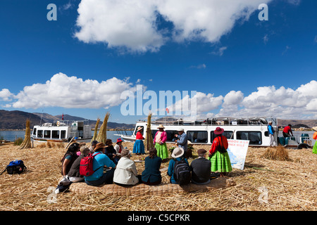 Eine Gruppe von Touristen auf einer Tour zu schwimmenden Inseln der Uros erhalten Informationen über den See und es Kultur vom TV-Programm. Stockfoto