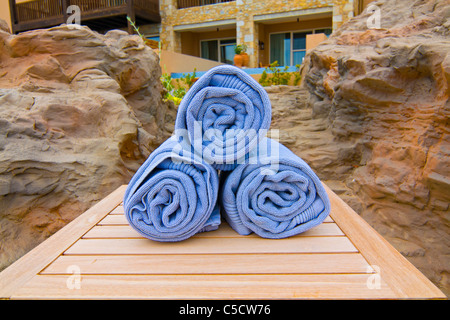 Set von drei blaue Handtücher eingewickelt auf einem Holztisch im resort Stockfoto