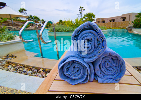 Set von drei blaue Handtücher eingewickelt auf einem Holztisch im resort Stockfoto