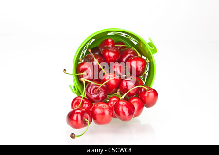 frische rote Kirschen in einer grünen Schale auf weißem Hintergrund Stockfoto