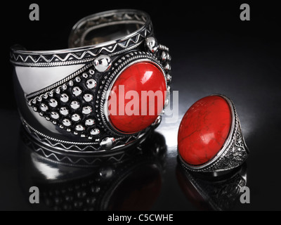 Armband und ein Ring mit roten Steinen. Schmuck auf schwarzem Hintergrund isoliert. Stockfoto