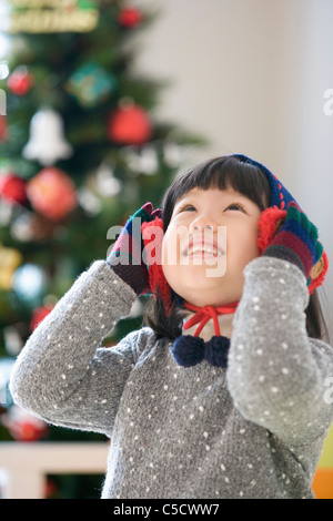 Mädchen ihr Ohrenschützer mit ihren Händen berühren und nachschlagen Stockfoto