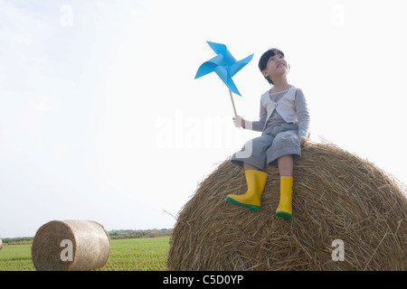 Mädchen halten Pin Räder auf die Reis-Garbe Stockfoto