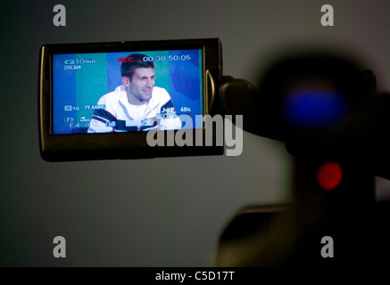 Novak Djokovic (SRB) gesehen in einem Kameramonitor auf einer Pressekonferenz während der 2011 Wimbledon Tennis Championships Stockfoto