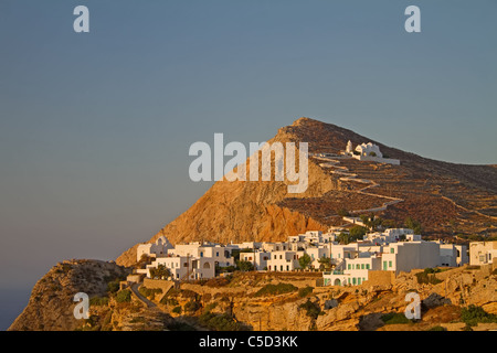 Die malerische Stadt Chora auf Folegandros Island, Griechenland, bei Sonnenuntergang; die Kirche der Jungfrau Maria sitzt oben drauf Stockfoto