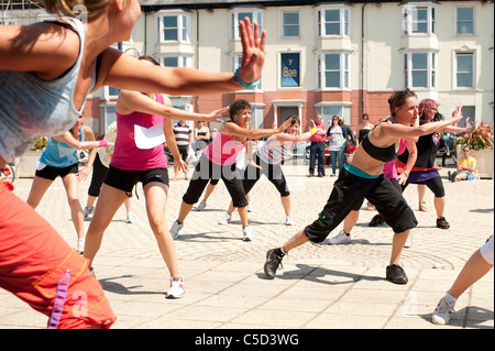 eine Gruppe von Frauen Zumba Tänzer aerobe Fitness Klasse auf Aberystwyth Promenade, Wales UK Stockfoto