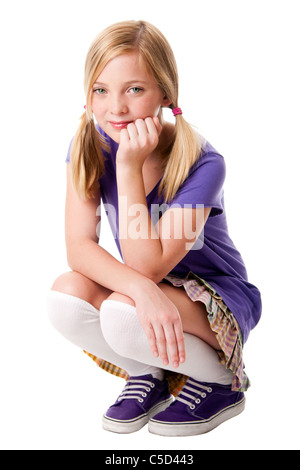 Schöne glücklicher Teenager-Mädchen sitzen hockte in Kniestrümpfe, lila sportliche Schuhe, Hemd und bunte Rock. Stockfoto