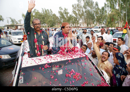 Sindh Gesetz Minister, Ayaz Soomro begrüßt wird von den Anhängern der Völker-Partei (PPP) während seiner Besuche in Larkana Stockfoto