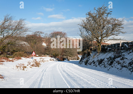 Schneebedeckte Straße in der Nähe von Hound Tor, Dartmoor, Devon, England, Großbritannien Stockfoto