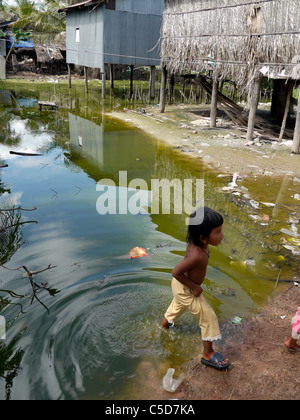 Kambodscha-Mädchen spielen in verschmutzten Teich. Kampot, Don Tok Dorf liegt an einer Flussmündung und ist oft vom Meerwasser überflutet. Stockfoto