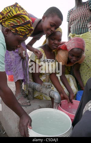 Tansania Dorf von Mwamalasa, Shinyanga. Sammeln von Wasser aus einem Vorratsbehälter. Das Wasser wird von Windmühlen in den Tank gepumpt. Stockfoto