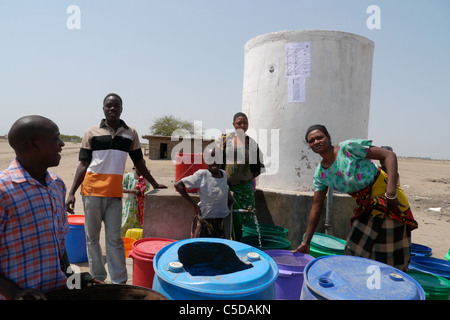 Tansania Dorf von Mwamalasa, Shinyanga. Sammeln von Wasser aus einem Vorratsbehälter. Das Wasser wird von Windmühlen in den Tank gepumpt. Stockfoto