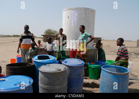 Tansania Dorf von Mwamalasa, Shinyanga. Sammeln von Wasser aus einem Vorratsbehälter. Das Wasser wird von Windmühlen in den Tank gepumpt. Stockfoto