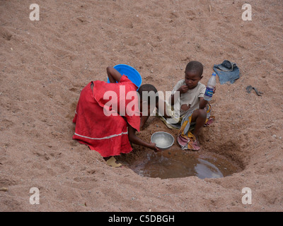 Tansania-Kinder sammeln von Wasser aus einem ausgetrockneten Fluss Bett in der Nähe von Shinyanga. Foto von Sean Sprague Stockfoto