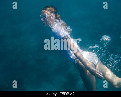 Eine Frau im warmen Meer schwimmen. Coco Palm Dhuni Kolhu. Baa Atoll, Malediven. Stockfoto