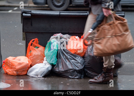 Smart urban Mann geht vorbei an Müllberge in East London Stockfoto