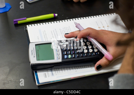 Studentin mit dunkler Nagellack verwendet Grafik-Taschenrechner über Notebook Pad während des Unterrichts an ihrer High School im Süden von Texas Stockfoto