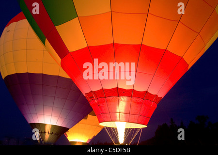 Leuchtende Heißluftballons in der Dämmerung Stockfoto