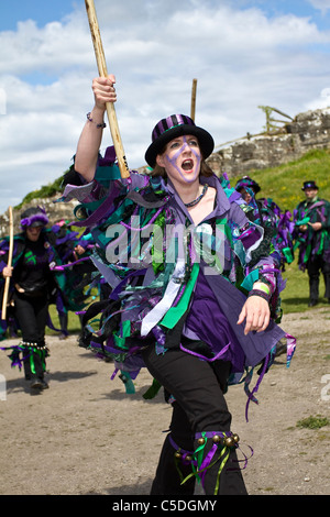 Exmoor Grenze gemischt Morris Dancers, schwarz, tragen lange fließende zerrissenen Lumpen, die Kleidung, die von der Breite schrauben, blau und weiß Material, Kleidung Stockfoto