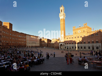 Gäste und Touristen beobachten den Sonnenuntergang über der Piazza del Campo in Siena, Toskana, Italien Stockfoto