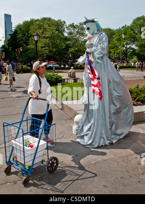 Ein Mime gekleidet wie die Statue of Liberty-Gespräche mit einem Passanten auf Fifth Avenue, Manhattan, New York City. Beachten Sie die Sonnenbrille. Stockfoto