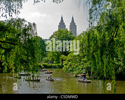 Sonntag Bootsfahrer Zeile auf dem See im Central Park in New York City. Im Hintergrund ist der Doppelturm San Remo Co-op, Central Park West Stockfoto