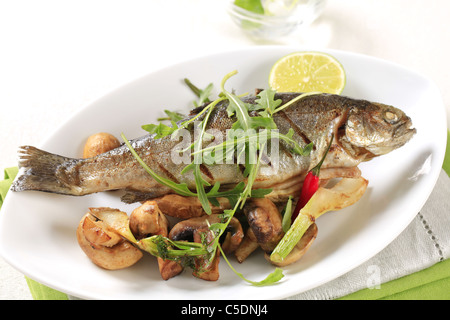 Schwenken Sie gebratene Forelle mit Champignons serviert Stockfoto