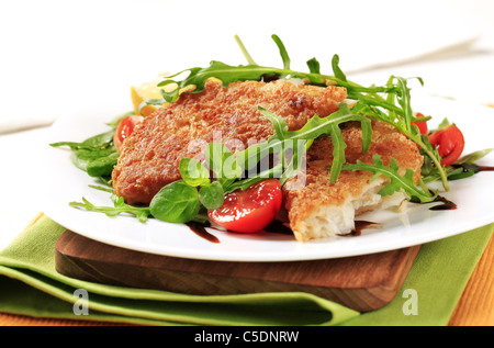 Gebratener Fisch auf einem Bett aus frischen Salat Stockfoto