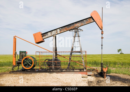 Seitenansicht von einer orange und schwarz rostig Ölpumpe auf ein Gebiet im mittleren Westen Stockfoto