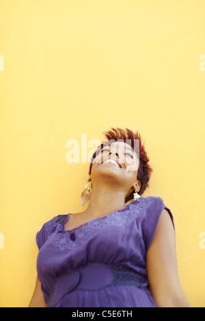 Portrait des afrikanischen College-Student lächelnd und blickte mit gelben Wand im Hintergrund. Tiefenschärfe, Textfreiraum Stockfoto
