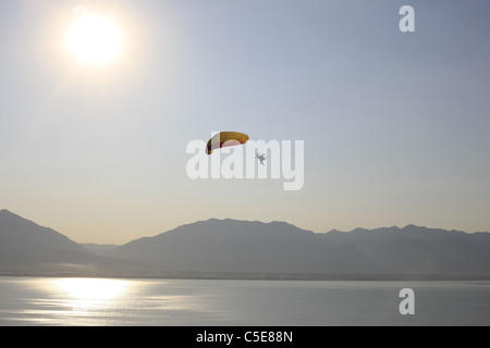 LUFT-LUFT-ANSICHT. Paramotorist, der Kunstflug über dem Utah Lake macht. Wasatch Mountains in der Ferne. Provo, Utah County, Utah, USA. Stockfoto