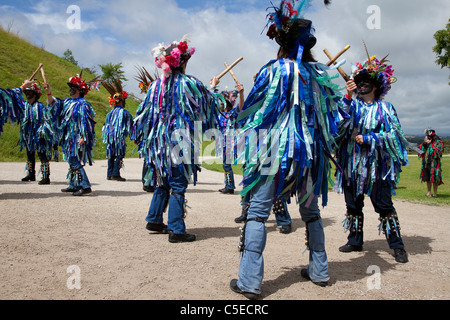 Exmoor Border Morris Tänzer, schwarz gesichtig, tragen lange fließende zerrissene alte Lumpen, Kleidung aus breiten Bolzen aus blauem und weißem Material, Kleidung & Tanzfeier, Outdoor-Veranstaltung, Straßentänzer, kostümierte Tänzer, lange fließende Lumpen, Cloggies, führen, Leistung der Volksunterhalter, mehrfarbige Musiker, beliebt, Durchführung der traditionellen ländlichen Unterhaltung in Tutbury Castle Weekend of Dance Derbyshire, Großbritannien. Stockfoto