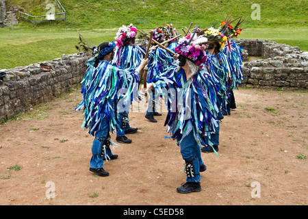 Exmoor Border Morris Tänzer, schwarz gesichtig, tragen lange fließende zerrissene alte Lumpen, Kleidung aus breiten Bolzen aus blauem und weißem Material, Kleidung & Tanzfeier, Outdoor-Veranstaltung, Street Dancer, kostümierte Tänzer, lange fließende Lumpen, Cloggies, führen, Leistung der Volksunterhalter, bunte Musiker, beliebt, Traditionelle Unterhaltung im Tutbury Castle Weekend of Dance Derbyshire, Großbritannien. Stockfoto