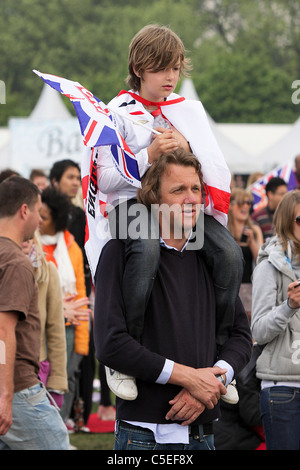 Die königliche Hochzeit Tag 2011, ein kleiner Junge sitzt in patriotische und festliche Accessoires auf seine Väter Schultern geschmückt. Stockfoto