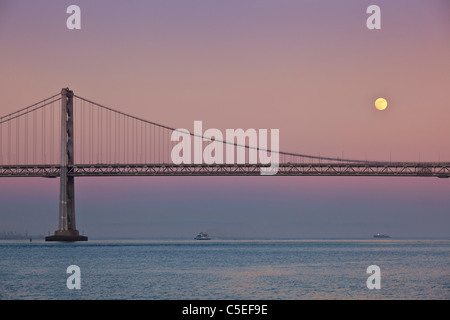 San Francisco Full Moon rising über die Oakland Bay Bridge Sonnenuntergang Kalifornien, Vereinigte Staaten von Amerika, USA Stockfoto