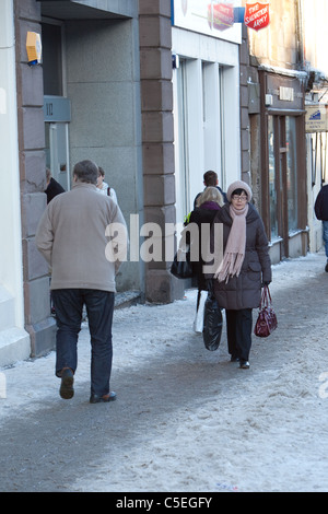 Fußgänger gehen im Winter vorsichtig auf frostigen Gehwegen Stockfoto