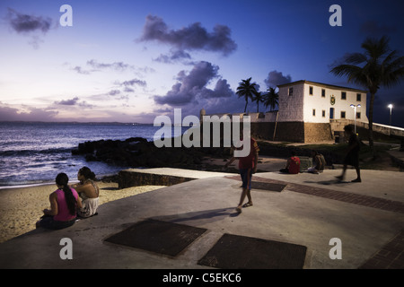 Menschen, die den Sonnenuntergang vor Forte de Santa Maria, Salvador, Brasilien Stockfoto