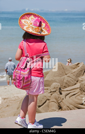 Ein junger Tourist trägt einen rosa Sombrero Spaziergänge entlang des Malecon, genießen den Blick auf Sand-Skulpturen und die Bucht von Banderas. Stockfoto