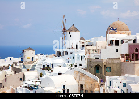 Oia, Santorini, griechische Insel, Griechenland, Europa ikonischen Windmühle weiß gewaschen Häuser und griechische Flagge Stockfoto